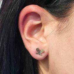 Photo of worn Butterfly-shaped earrings faceted wings yellow and white gold