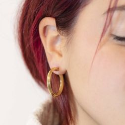 photo of worn Yellow Gold Arrow Shaped striped hoop earrings with shiny side