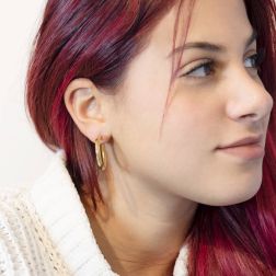 photo of worn Yellow Gold Arrow Shaped striped hoop earrings with shiny side