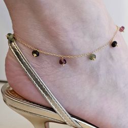 Photo of worn Yellow gold anklet with tourmaline pendants.