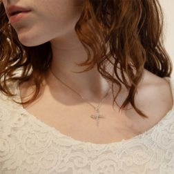 Photo of worn Stylized Infinity Cross pendent with zircons in white gold