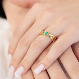 Photo of worn Emerald Solitaire with crossed Yellow Gold bands