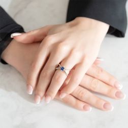 Photo of worn X shaped Solitaire Ring with Blue Sapphire in White Gold