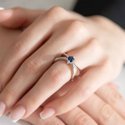 Photo of worn X shaped Solitaire Ring with Blue Sapphire in White Gold
