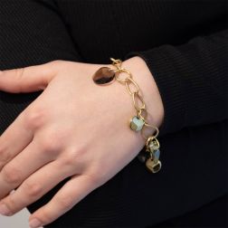 photo of worn Yellow Gold chain bracelet with Gold and Topaz pendants