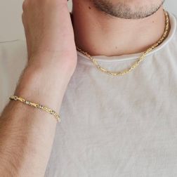 Photo of worn Tubular bracelet with round striped partridge eye in yellow gold alternating with 2 white eyelets