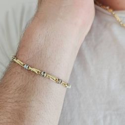 Photo of worn Tubular bracelet with round striped partridge eye in yellow gold alternating with 2 white eyelets