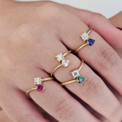 Photo of worn Contrariè ring with 2 zircons, coloured heart, in yellow gold