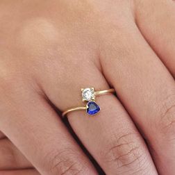 Photo of worn Contrariè ring with 2 zircons, coloured heart, in yellow gold