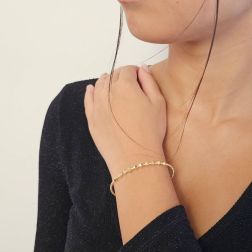 Photo of worn Open bangle bracelet with balls and three-dimensional rhombuses in yellow gold
