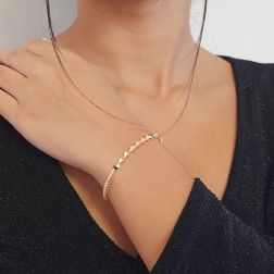 Photo of worn Open bangle bracelet with balls and three-dimensional rhombuses in yellow gold