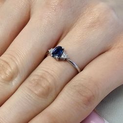 Photo of worn 6x4mm Oval Blue Sapphire Solitaire Ring with 6 Diamonds in White Gold