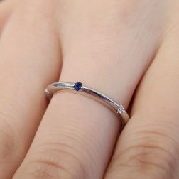 Photo of worn Thin pyramid-shaped ring with alternating diamonds, blue sapphires, rubies and emeralds
