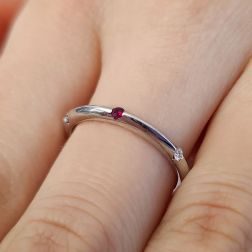 Photo of worn Thin pyramid-shaped ring with alternating diamonds, blue sapphires, rubies and emeralds