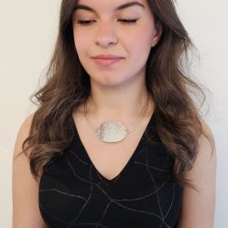 photo of worn Semi-rigid curved medallion necklace in white gold