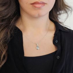 photo of worn Teardrop-shaped aquamarine pendant with 10 pavé-set diamonds