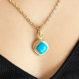 photo of worn Round pendant with a turquoise rhombus-shaped cabochon and 18kt yellow gold