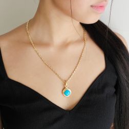 photo of worn Round pendant with a turquoise rhombus-shaped cabochon and 18kt yellow gold