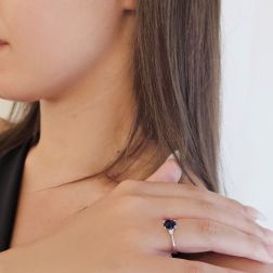 photo of worn Oval Blue Sapphire Solitaire Ring 7x5mm with 2 Diamonds in White Gold