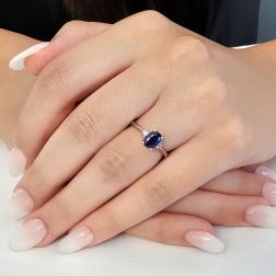 photo of worn Oval Blue Sapphire Solitaire Ring 7x5mm with 2 Diamonds in White Gold